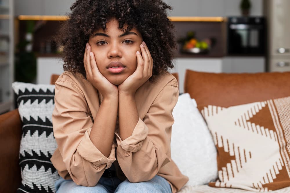 Woman with curly hair resting chin on hands