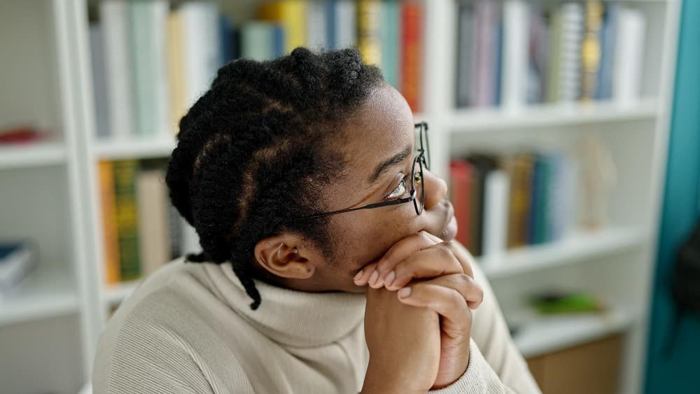 Woman with braided hair looking at bookshelf